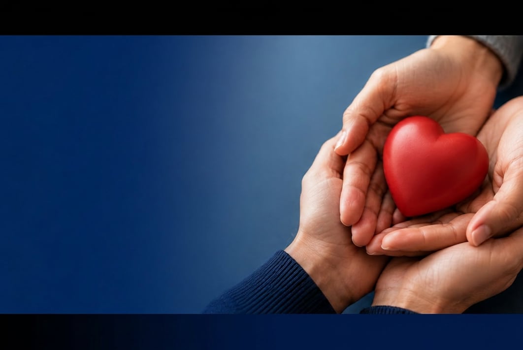 Two pairs of hands gently holding a red heart